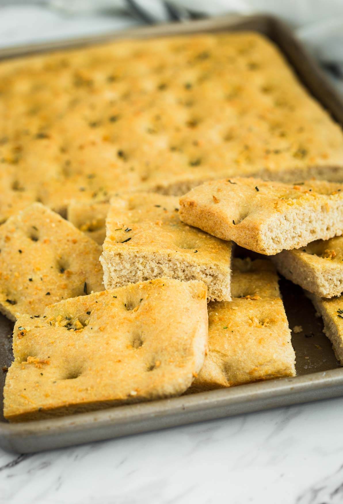 whole wheat focaccia bread cut into pieces in a baking sheet pan.