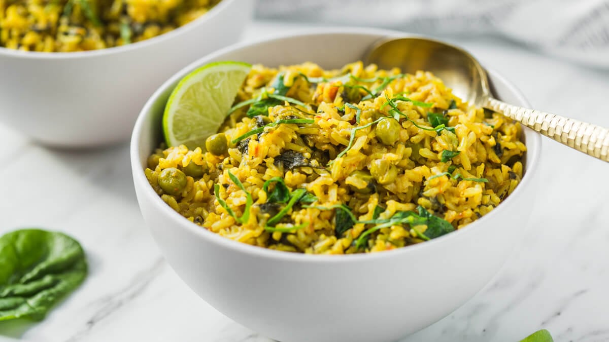 Spinach with brown rice and green peas in a serving bowl