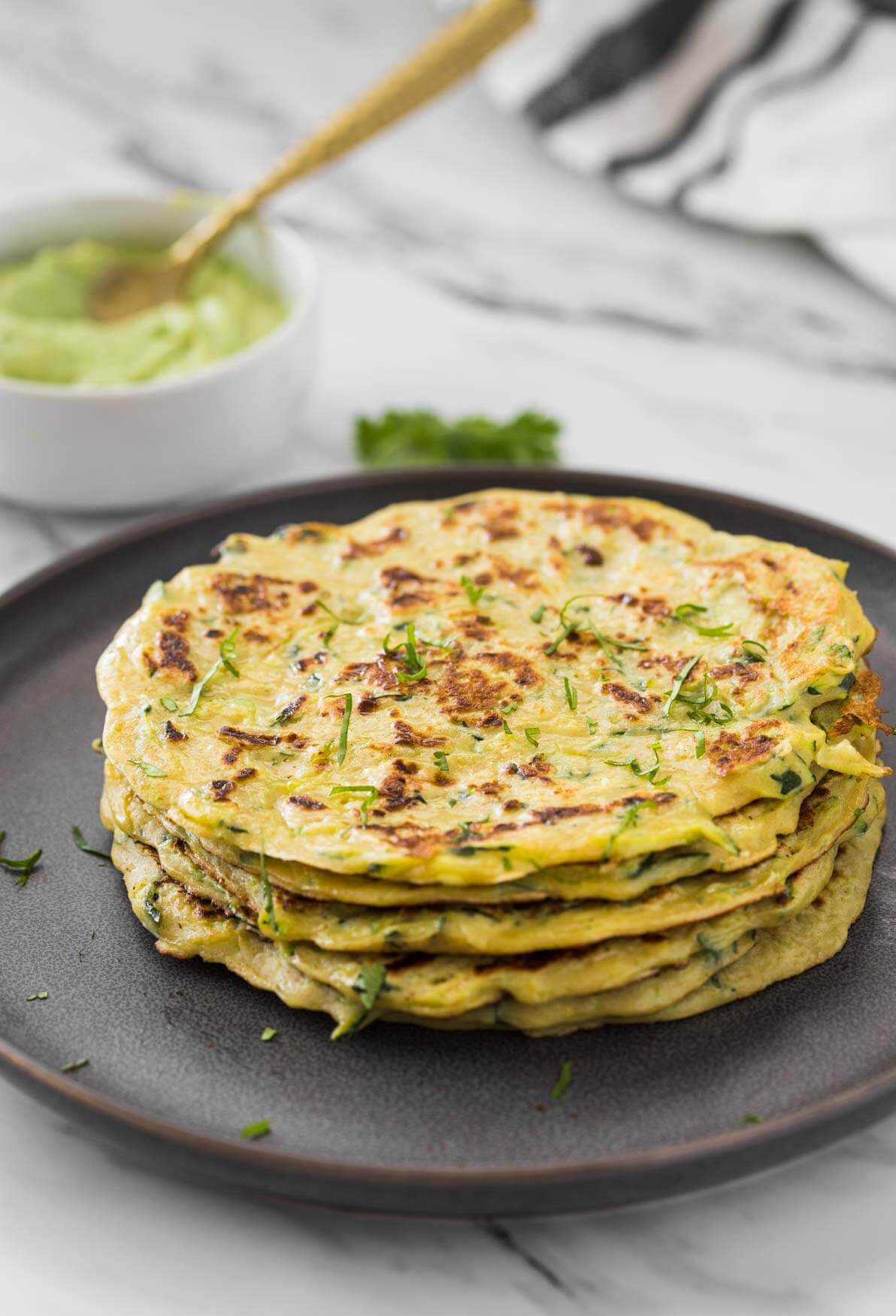 Healthy zucchini pancakes stacked in a serving plate