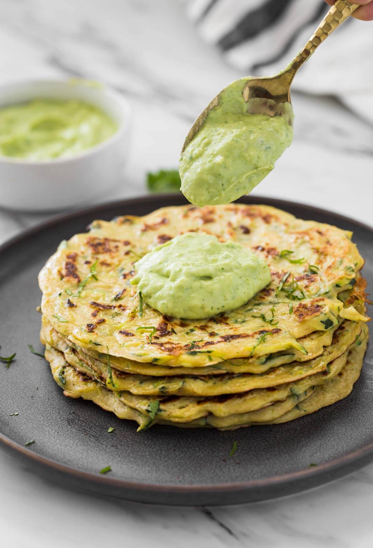 Healthy zucchini pancakes stacked in a serving plate