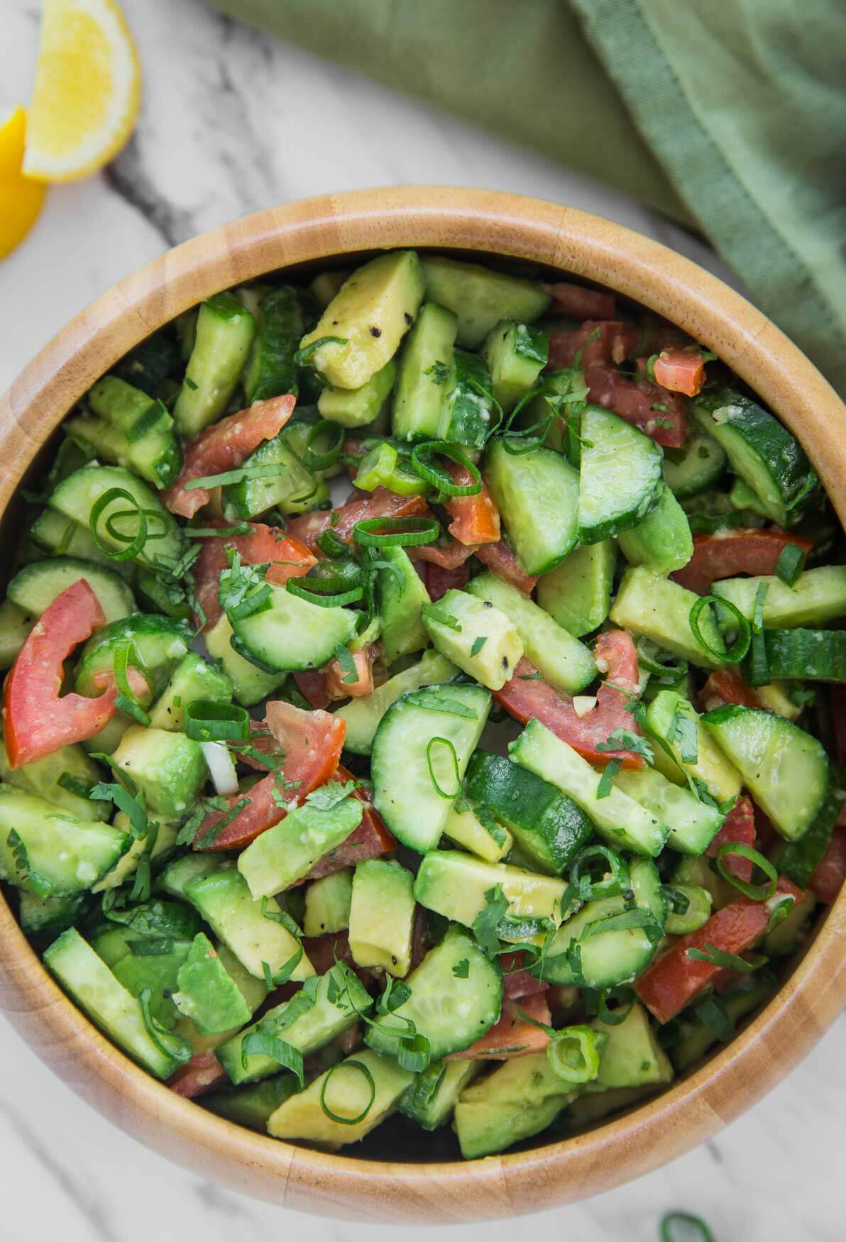photo of healthy avocado cucumber salad in a large wooden bowl