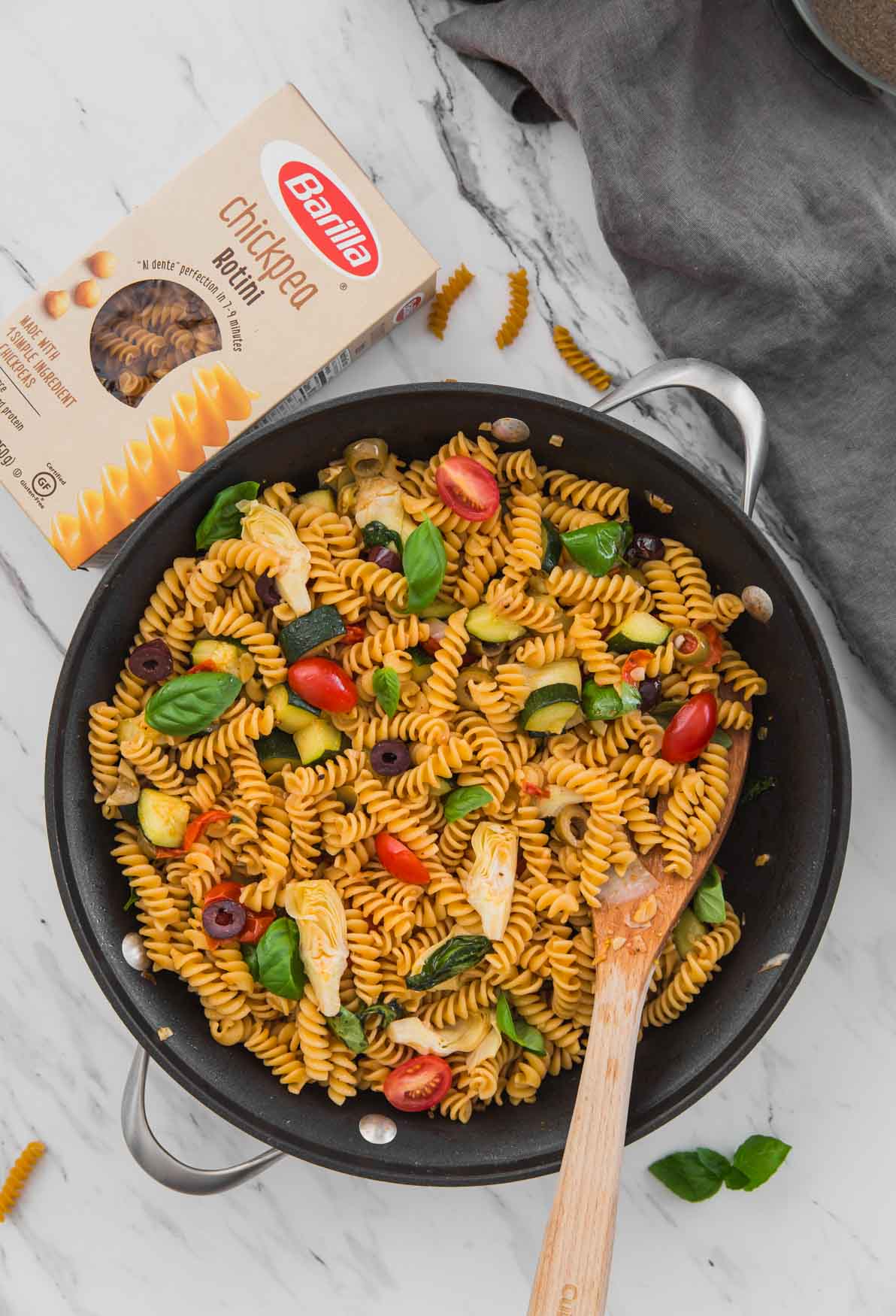 Healthy Mediterranean Pasta with artichoke, olives, and tomato in a large skillet