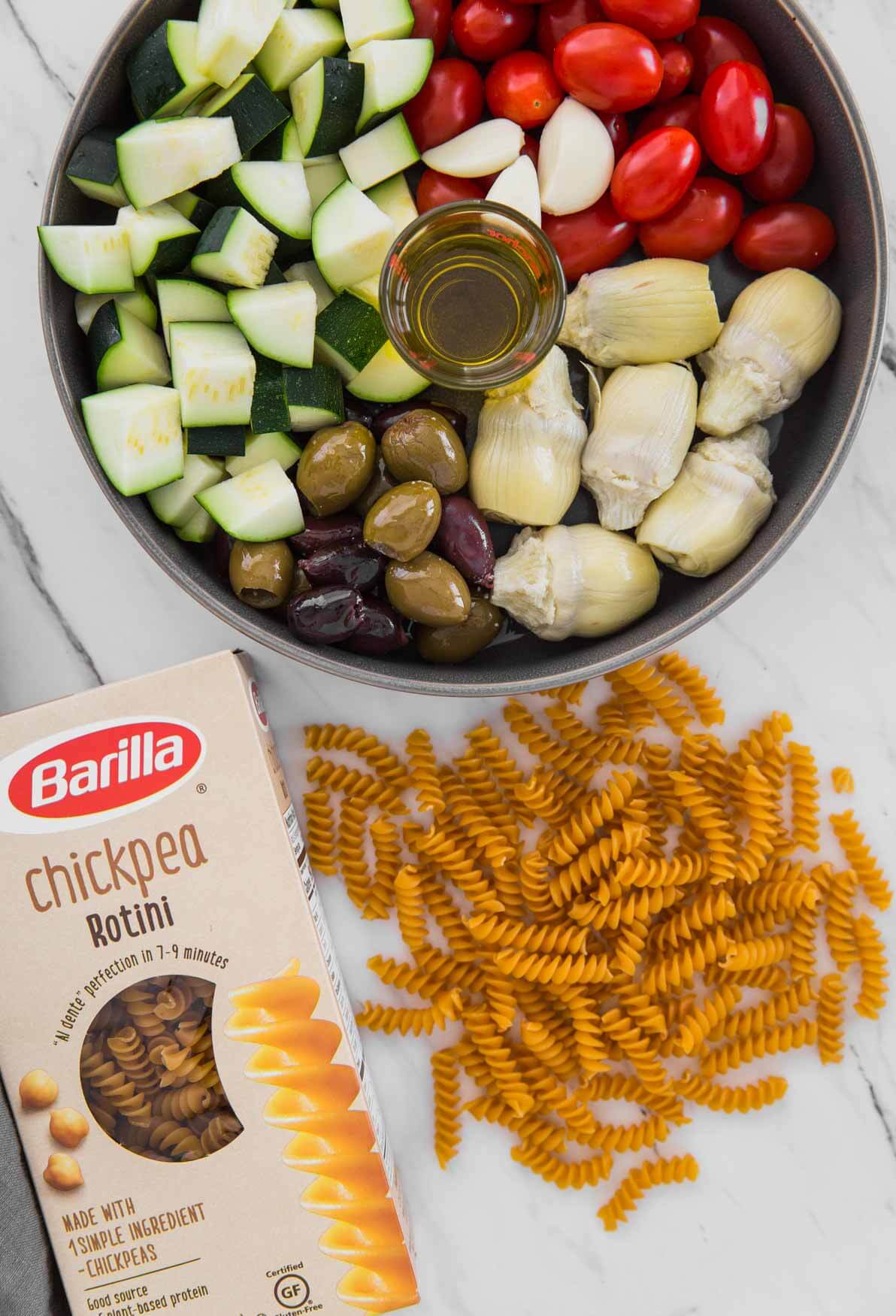 fresh ingredients and rotini pasta for making pasta with artichokes and olives