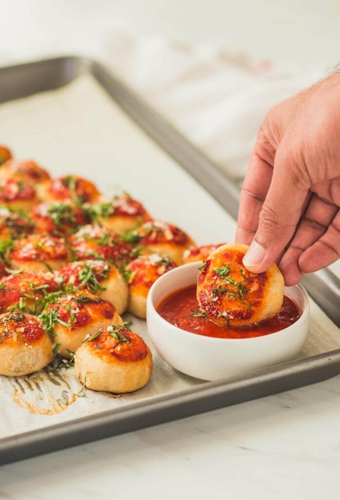 Christmas tree pizza bites with pizza sauce on the side for dipping.