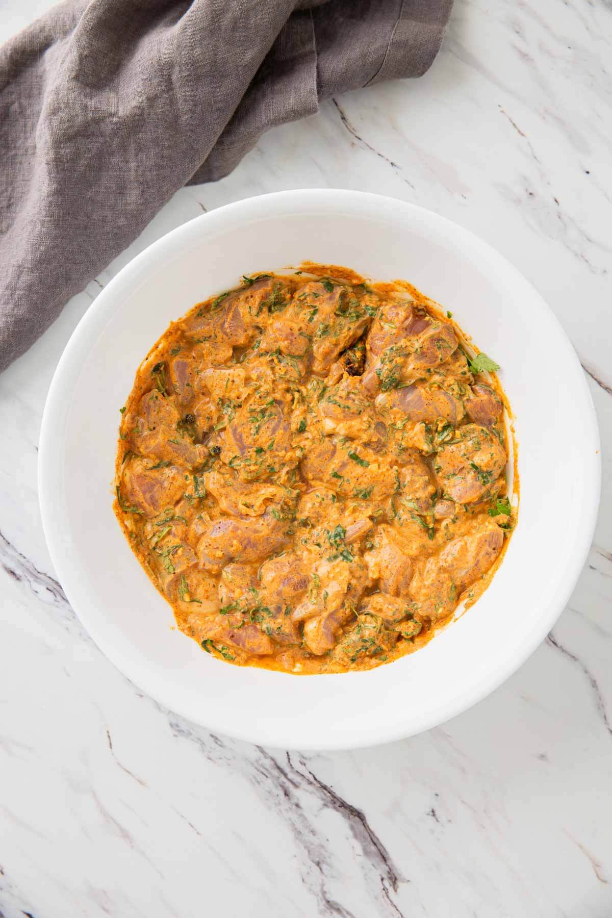 chicken pieces marinated with Indian spices in a large mixing bowl