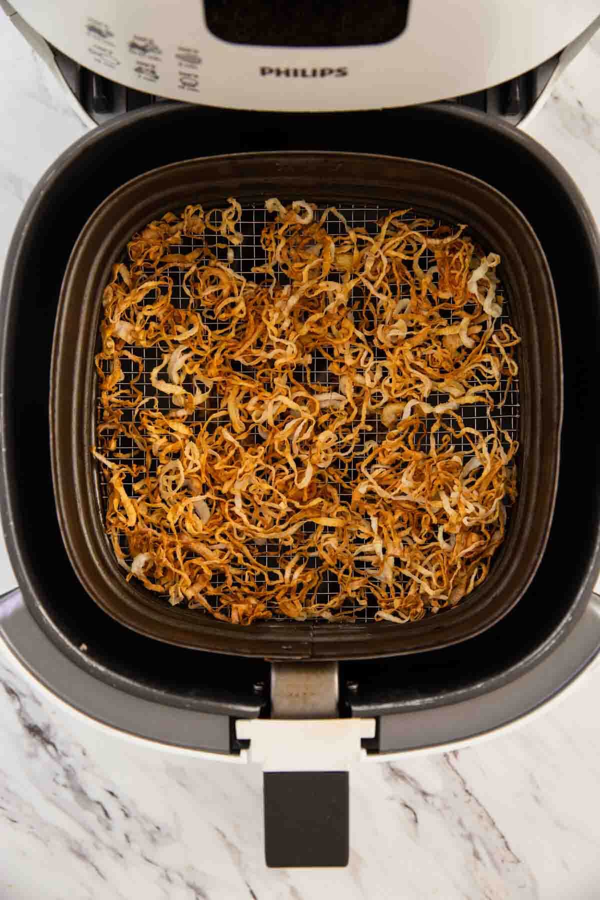 * Air fryer crispy onions after the frying process is done.