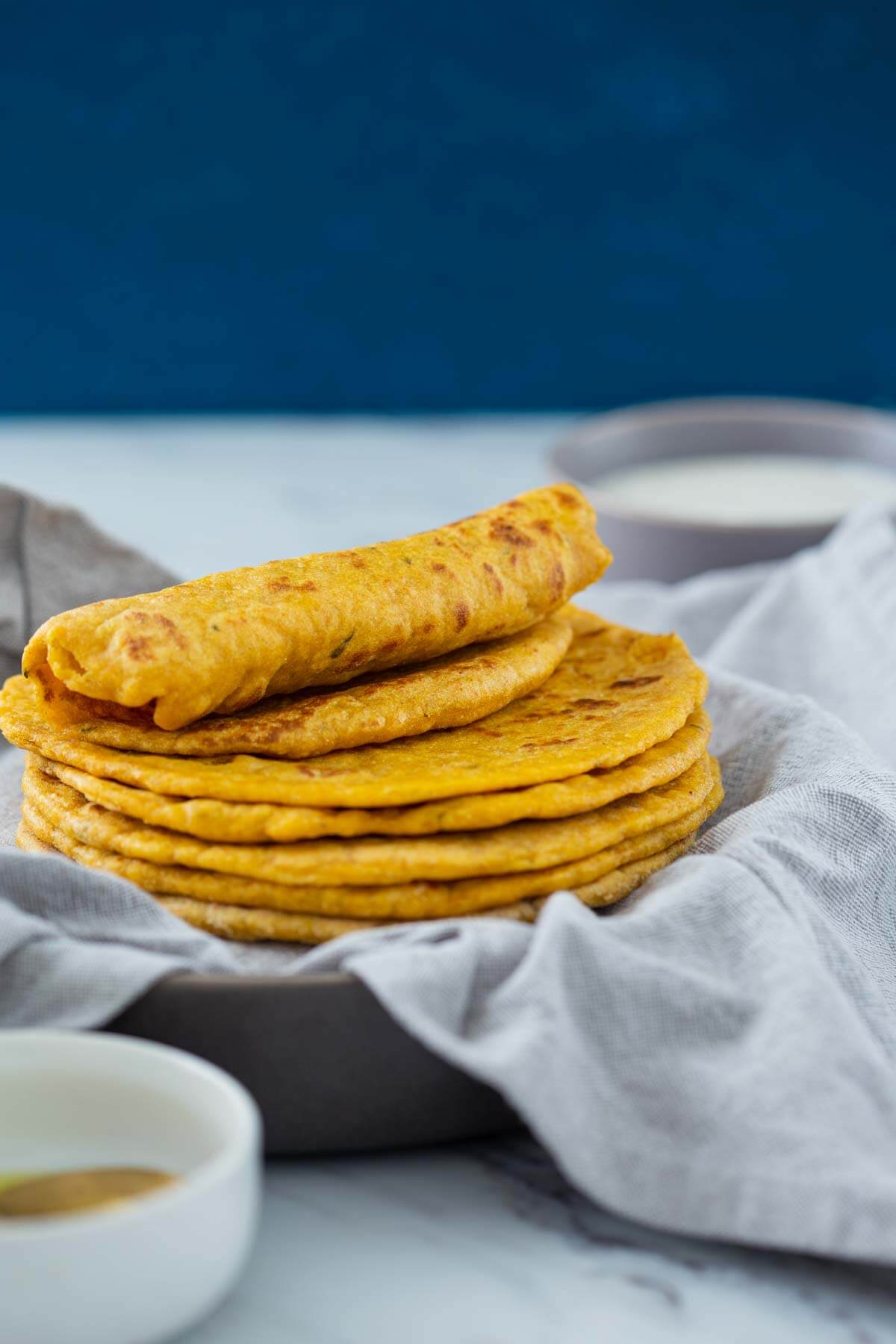 Pumpkin flatbreads stacked in a serving dish are read to serve.