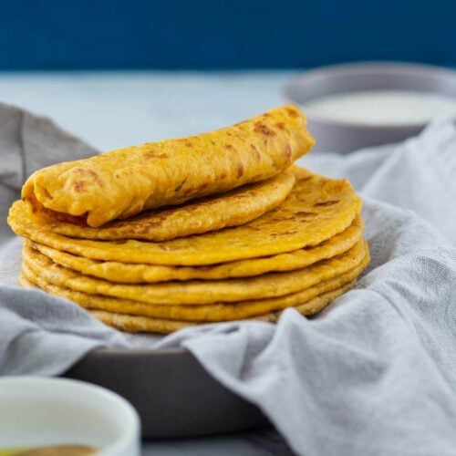Pumpkin flatbreads stacked in a serving dish are ready to serve.