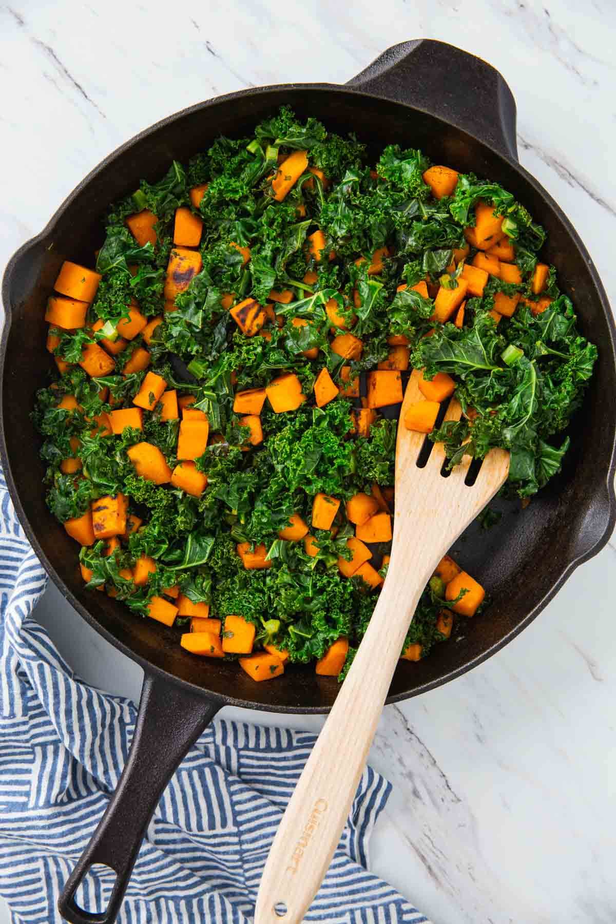 Sweet potato and kale roasted in a cast iron pan.