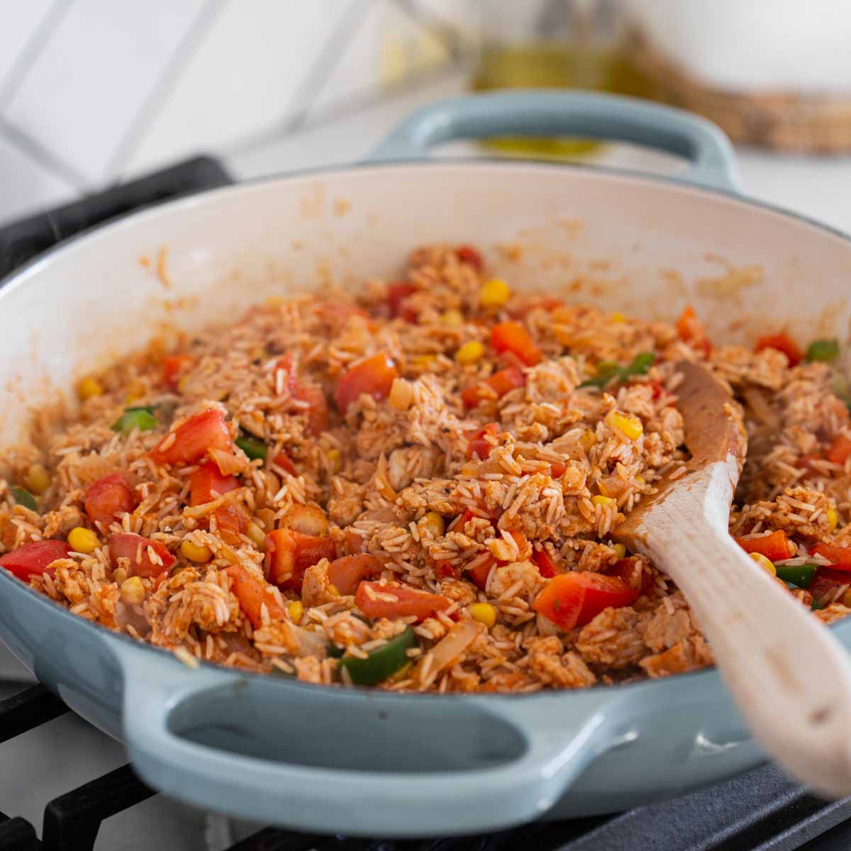 sautéing rice with diced veggies, ground chicken, and Mexican spices in a large skillet.