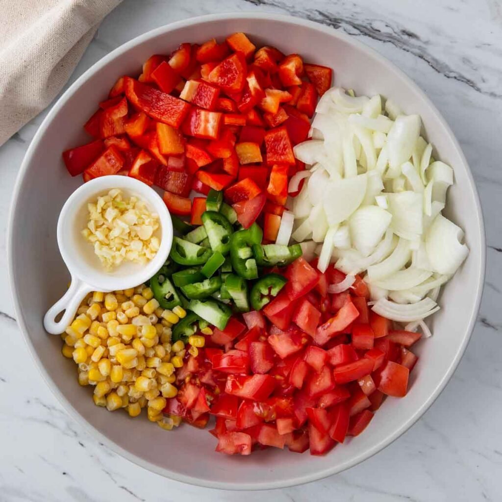 diced veggies, corn and chopped garlic in a large shallow dish