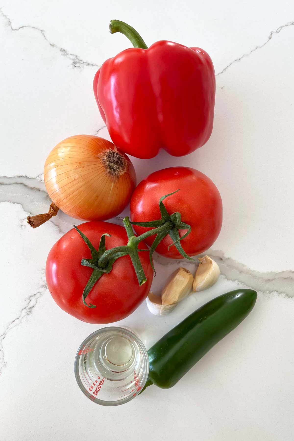 Fresh tomato, red bell pepper, jalapeño pepper, onion, garlic, and oil gathered for making healthy Mexican taco rice.