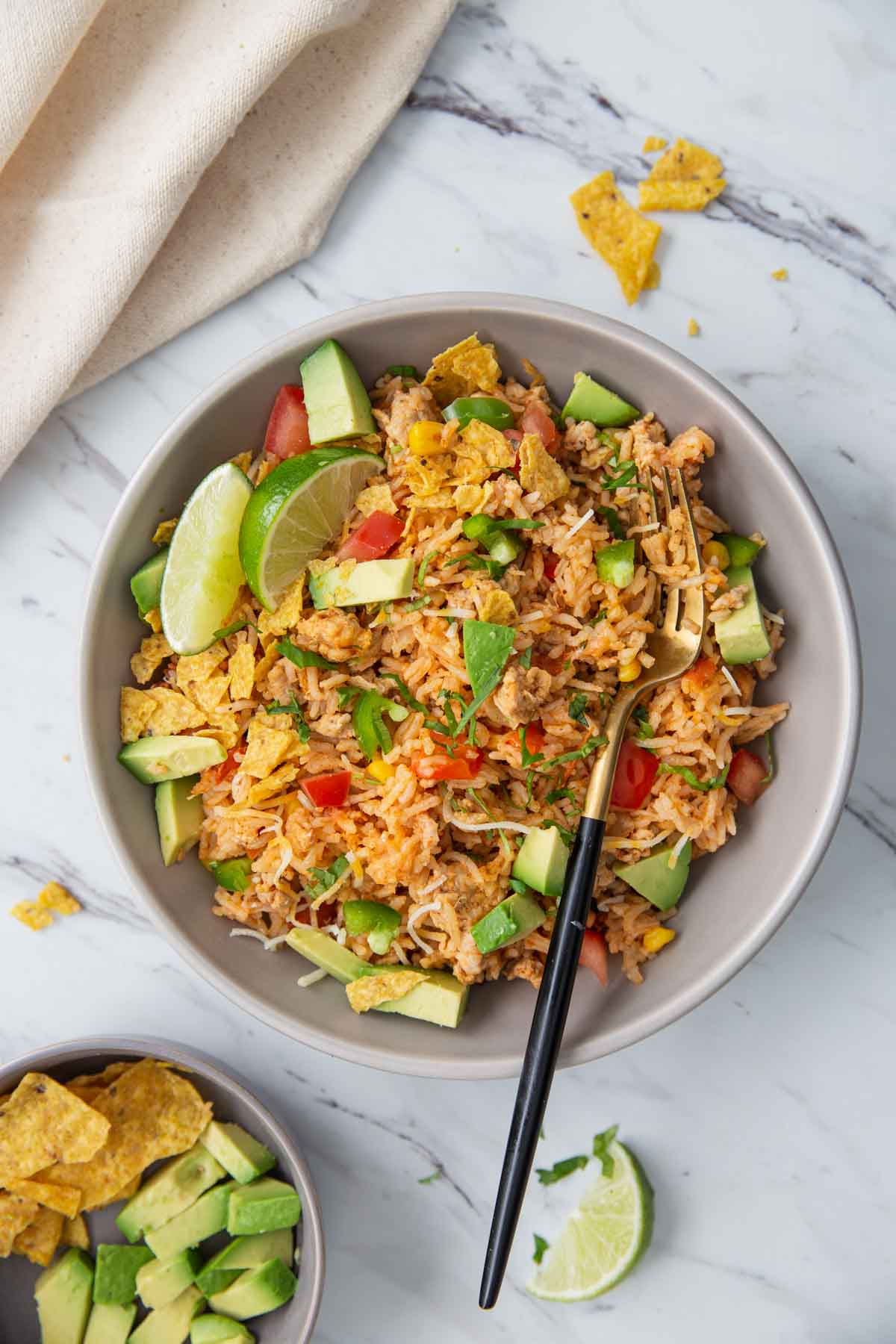 Cheesy chicken taco rice in a serving dish with a serving spoon.