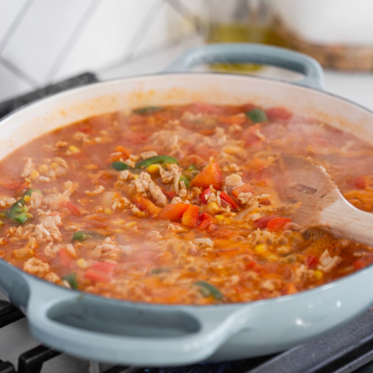 cooking rice with diced veggies, ground chicken, and Mexican spices in a large skillet.