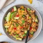 Image of Mexican taco rice in a serving dish with serving spoon. It has text overlay that reads 'one skillet chicken taco rice casserole'.