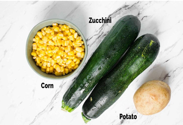 Corn kernels in a bowl, potato and zucchini for making fritters.