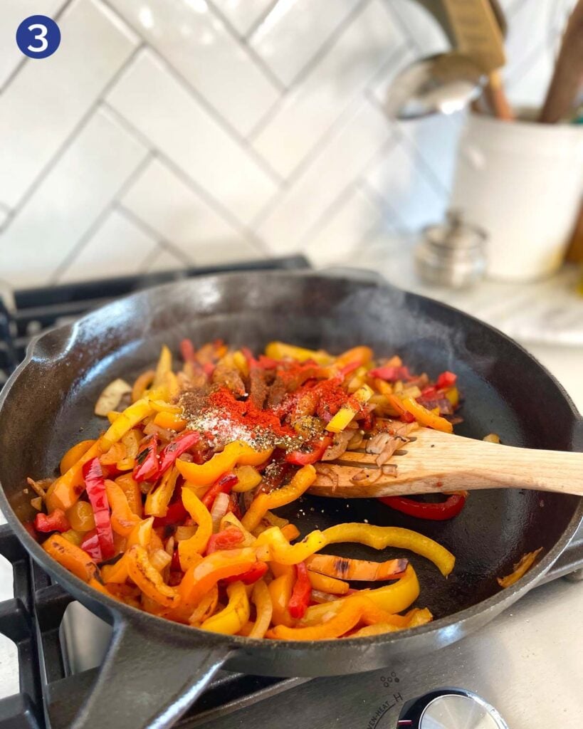 Roasting sliced peppers and onion with fajita seasonings in a cast iron pan.