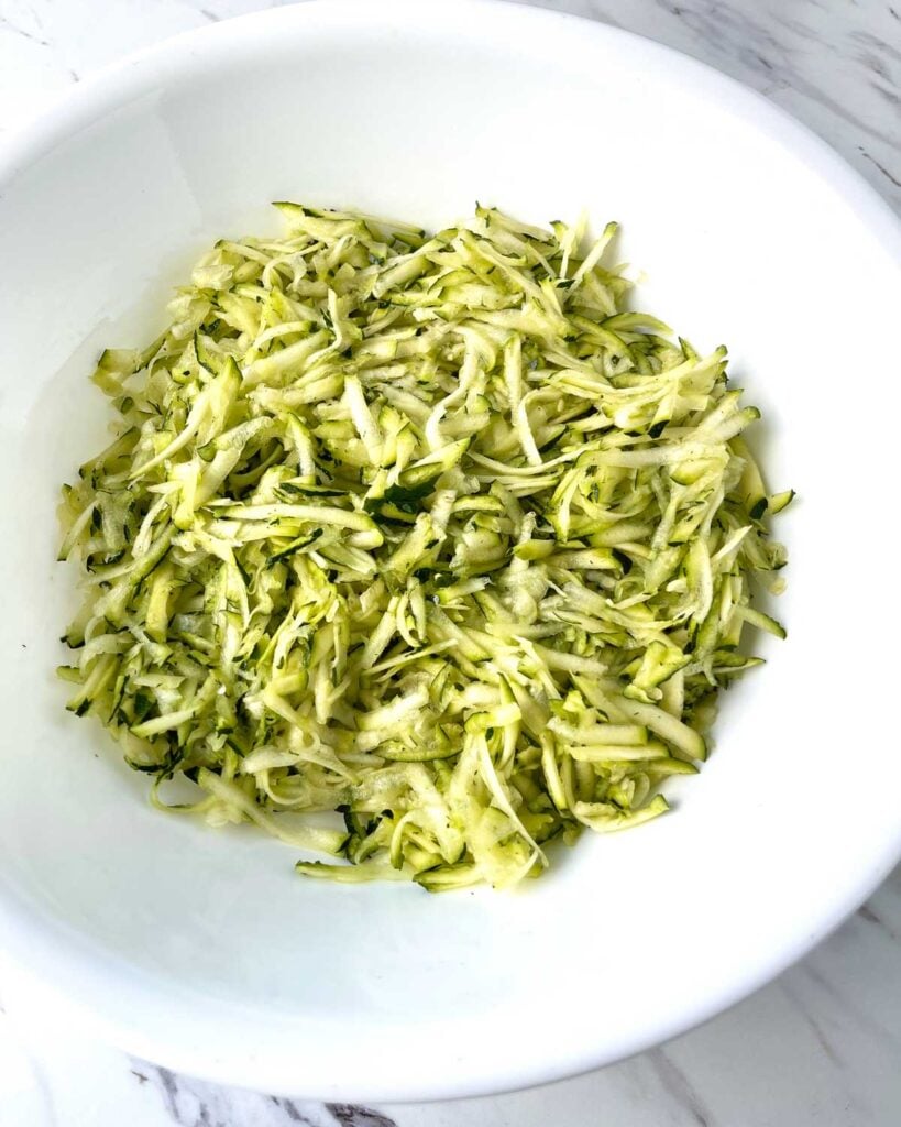 Shredded zucchini in a large bowl.