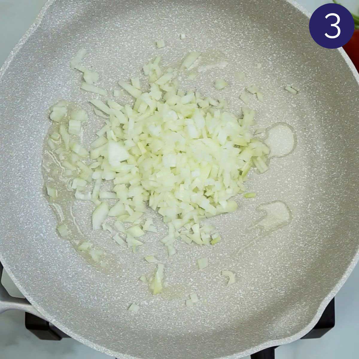 Sautéing diced onion in oil in a large skillet for making shrimp curry.