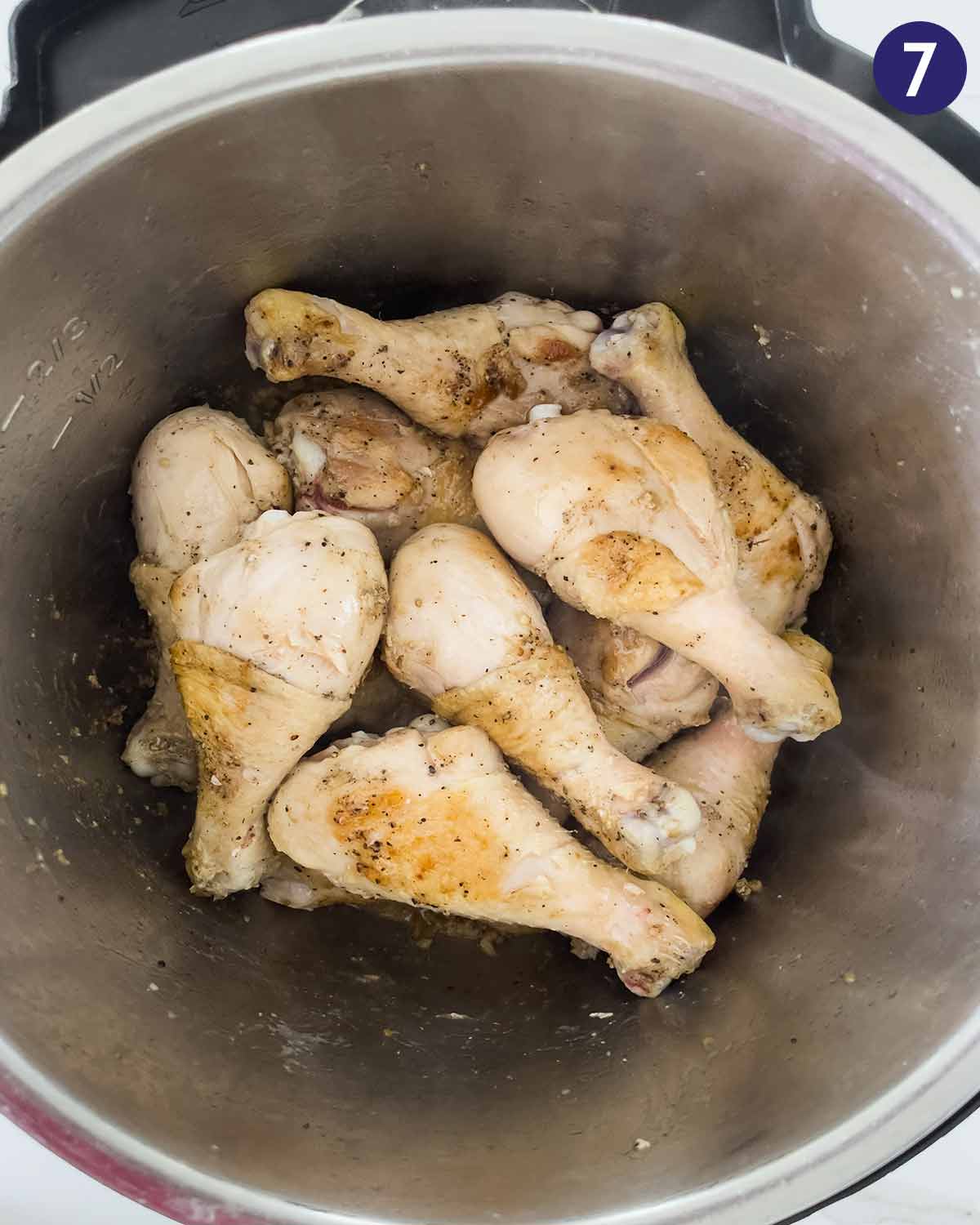 Chicken drumsticks layered in Instant Pot for pressure cooking.
