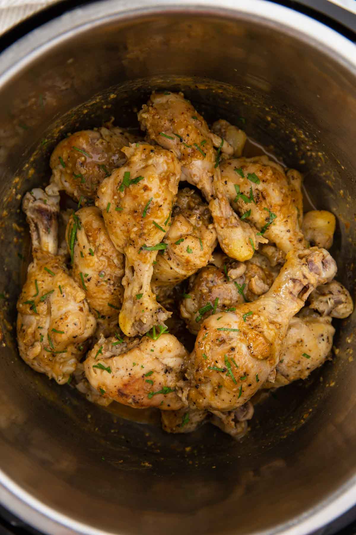 Instant Pot chicken drumsticks with lemon garlic sauce and garnished with fresh parsley.