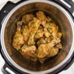 Chicken drumsticks in Instant Pot coated with lemon garlic sauce and garnished with fresh parsley.