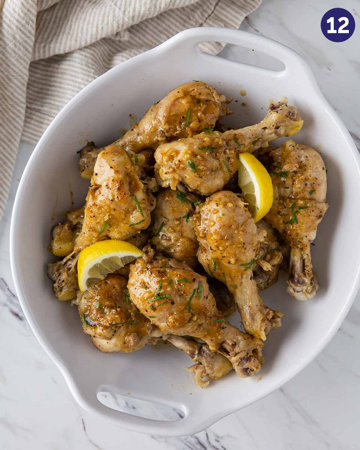 Chicken drumsticks with lemon garlic sauce in a serving dish.