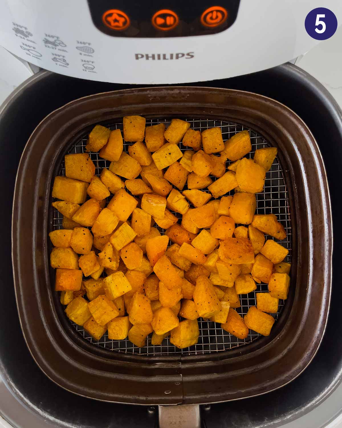 Diced butternut squash in Air Fryer basket at the end of cooking.