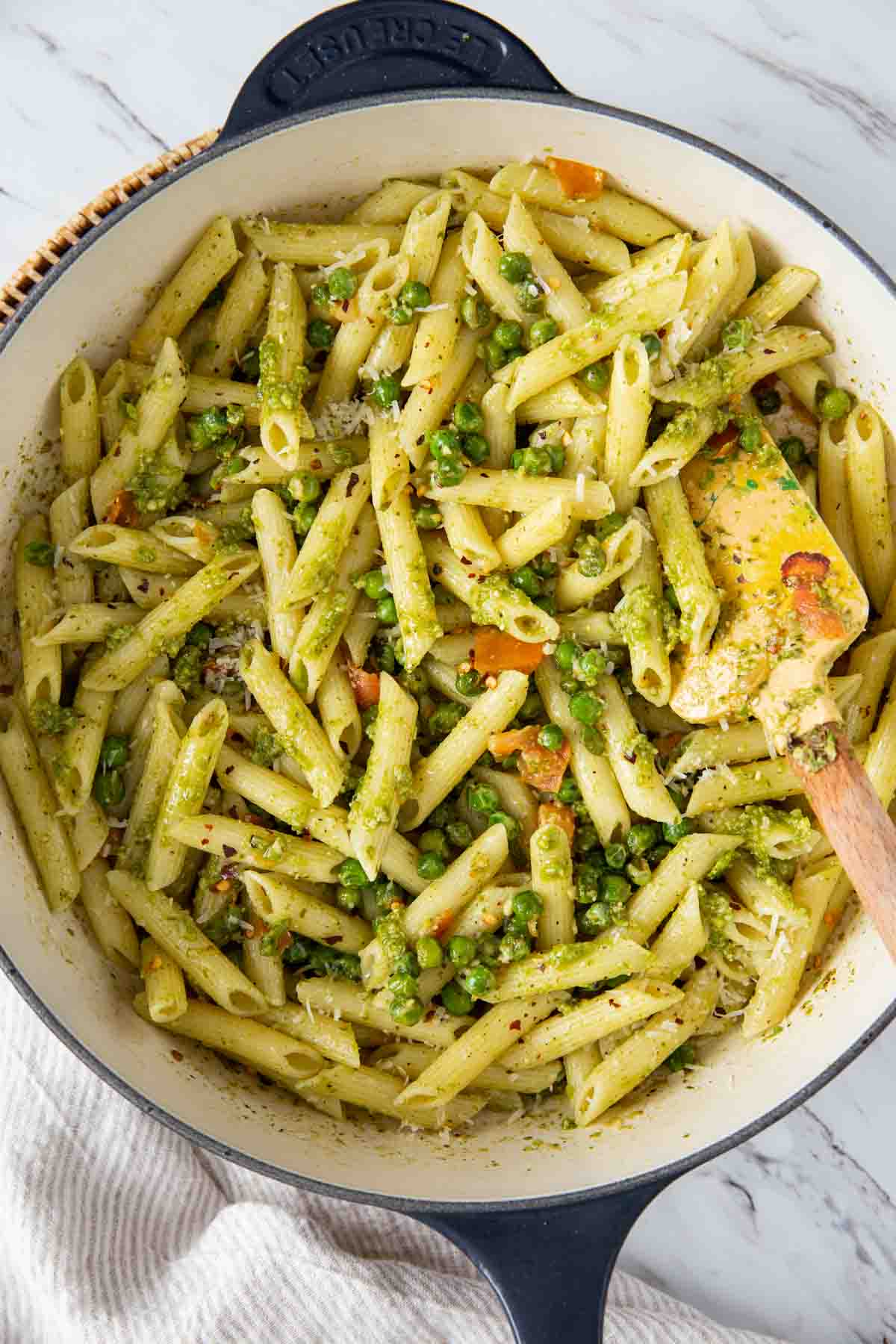Pesto pasta with peas in a large pan.