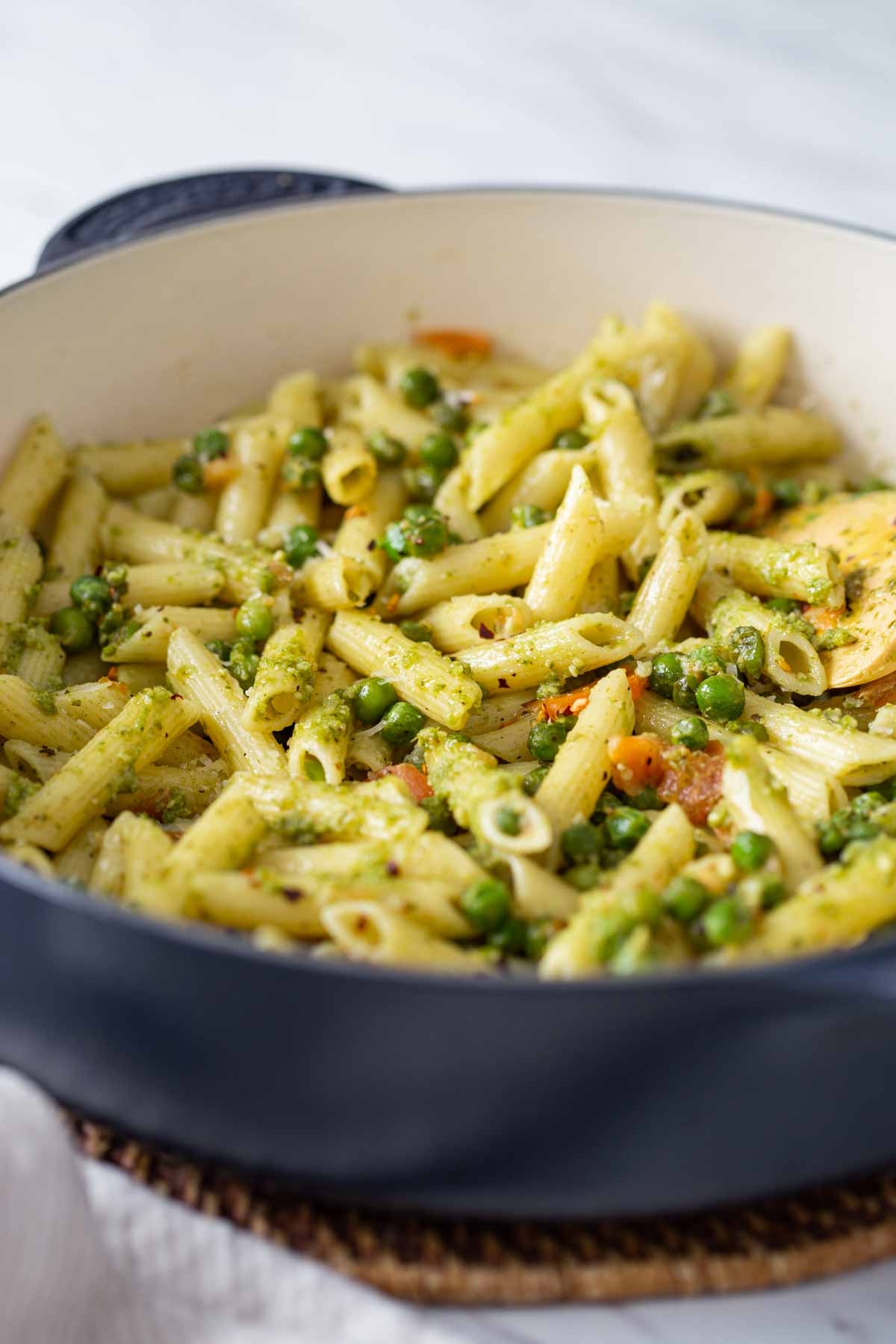 Pesto pasta with peas in a large pan.