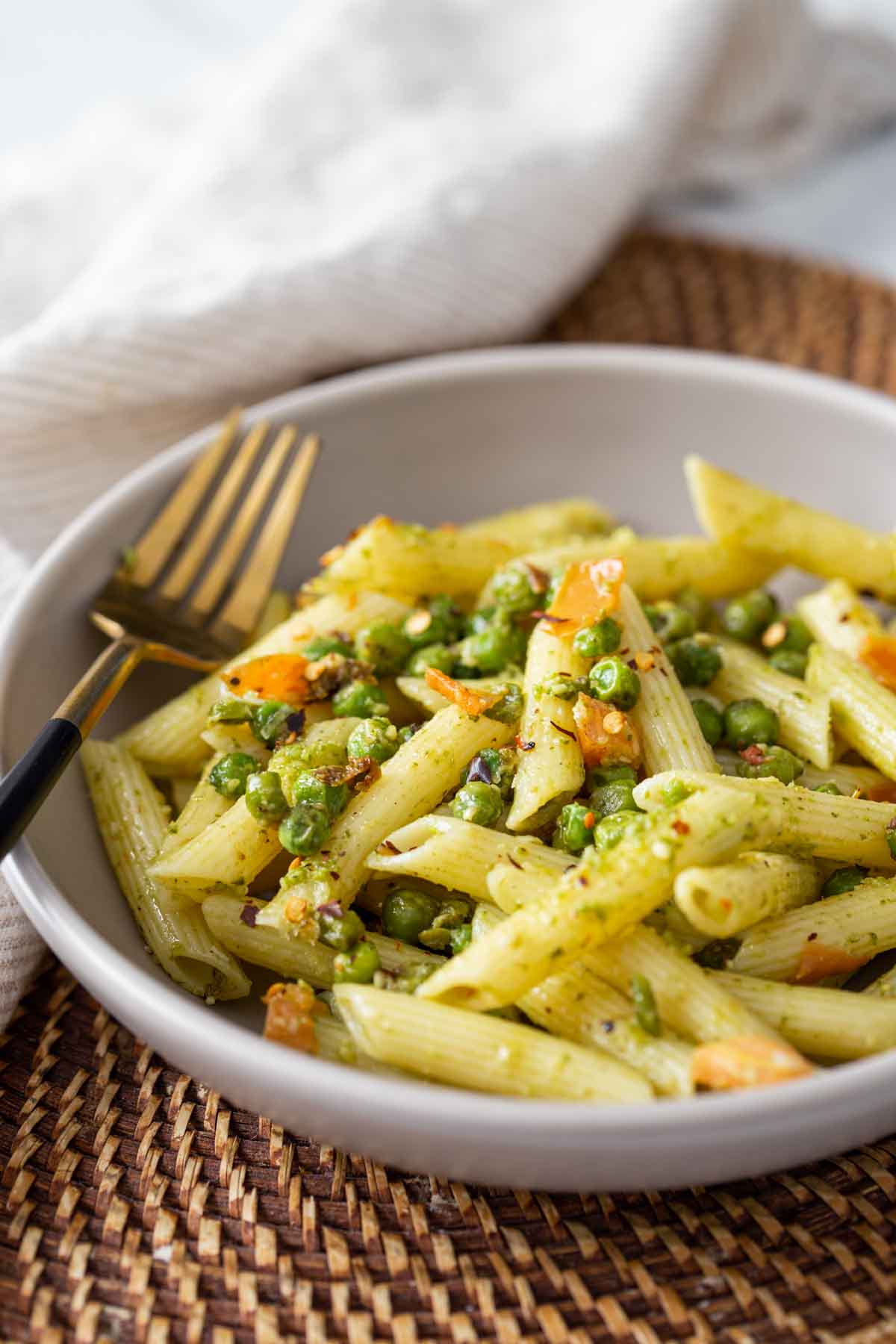 Pesto and Peas pasta in a served in a  dish with a metal fork.