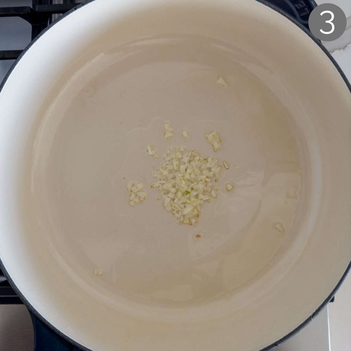 Sautéing garlic in some oil in a large pan.