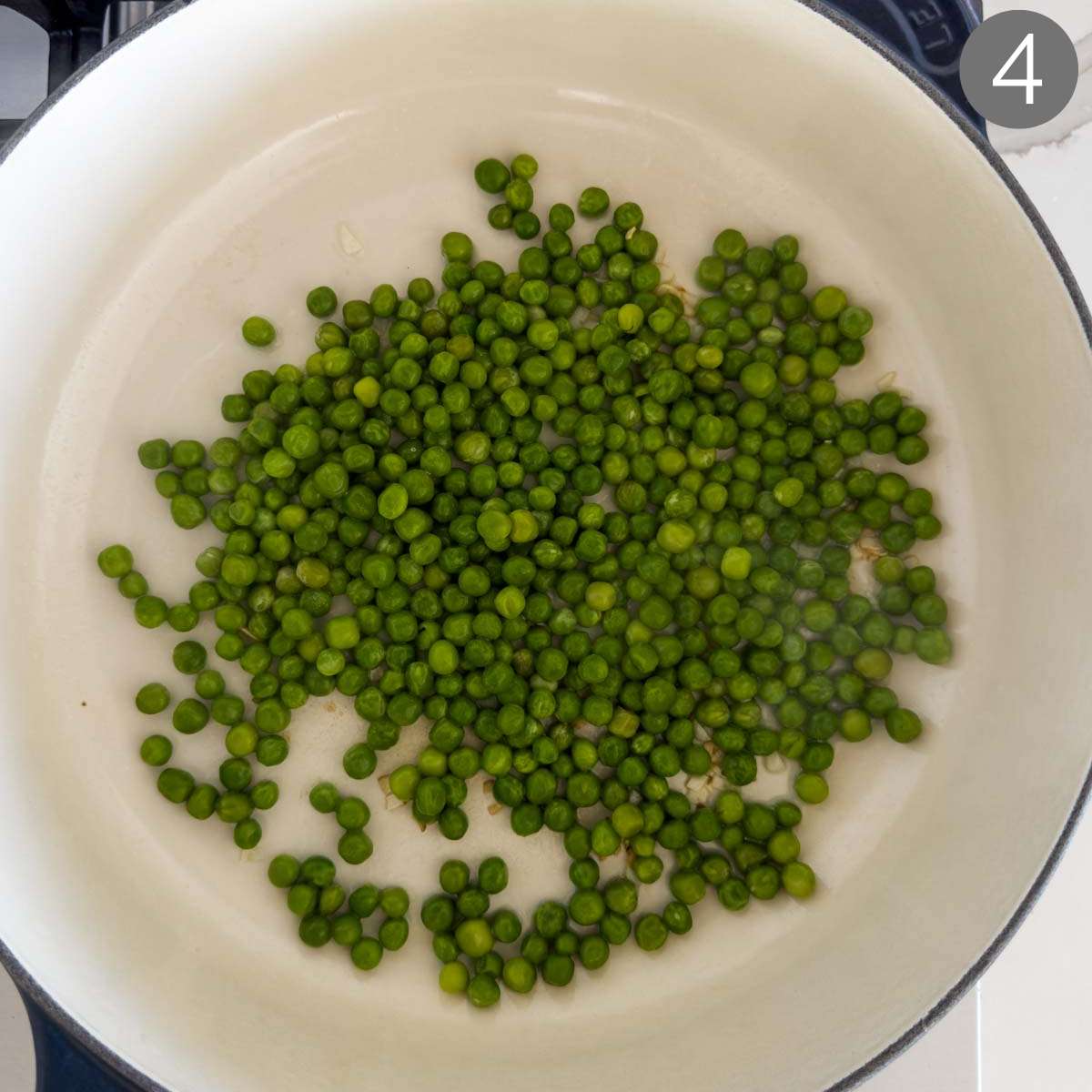 Sautéing green pean with garlic in a large pan.