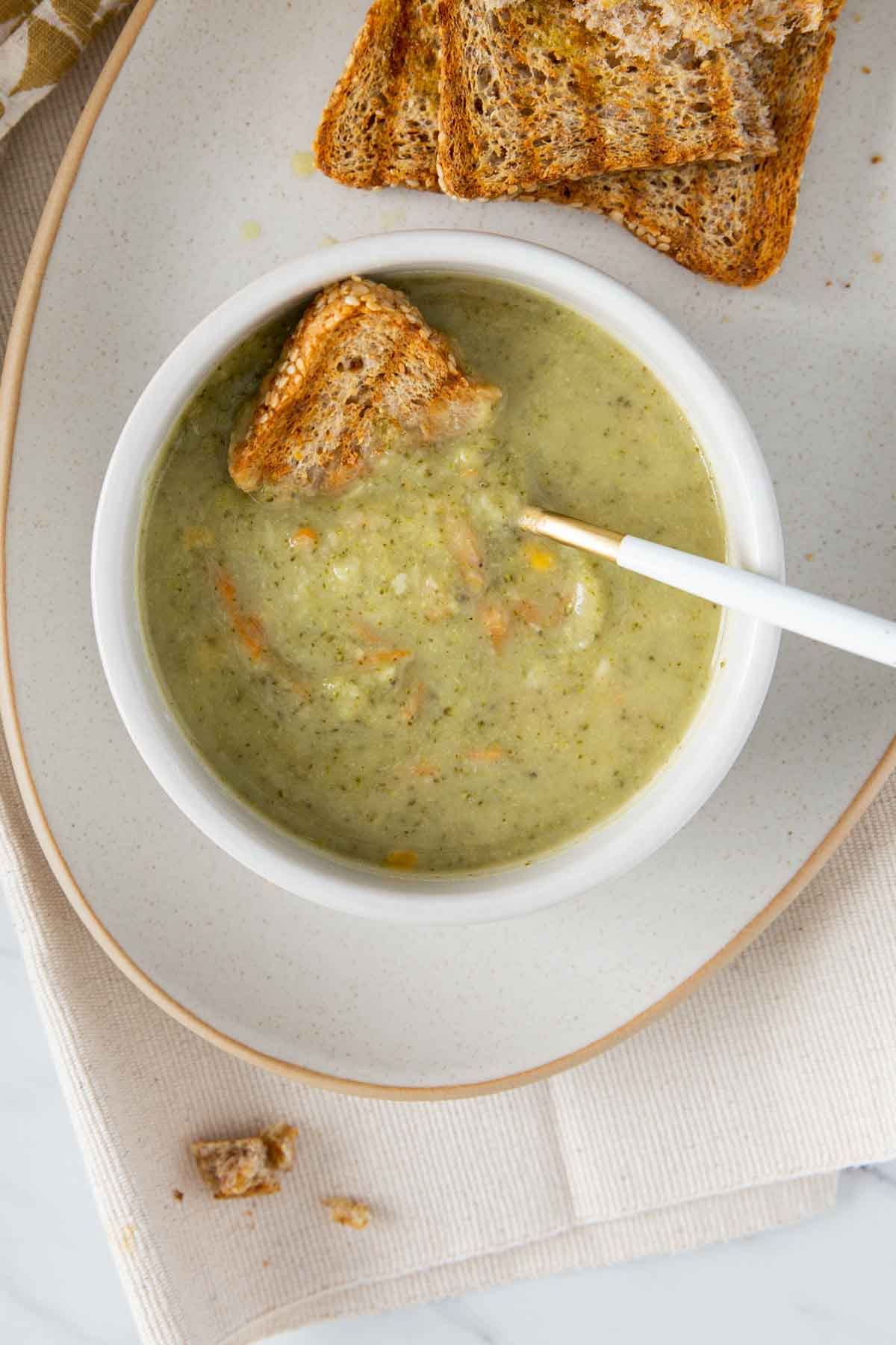 Healthy Instant Pot broccoli cheddar soup served in a soup bowl with toasted bread on the side.