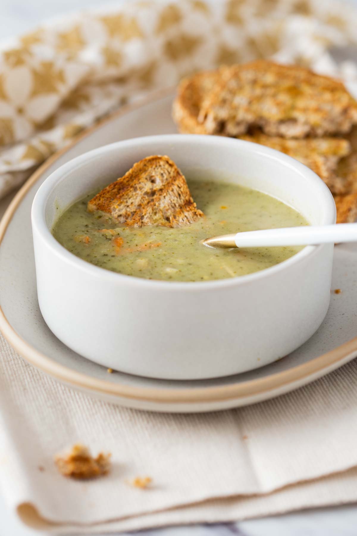 Healthy Instant Pot broccoli cheddar soup served in a soup bowl with toasted bread on the side.