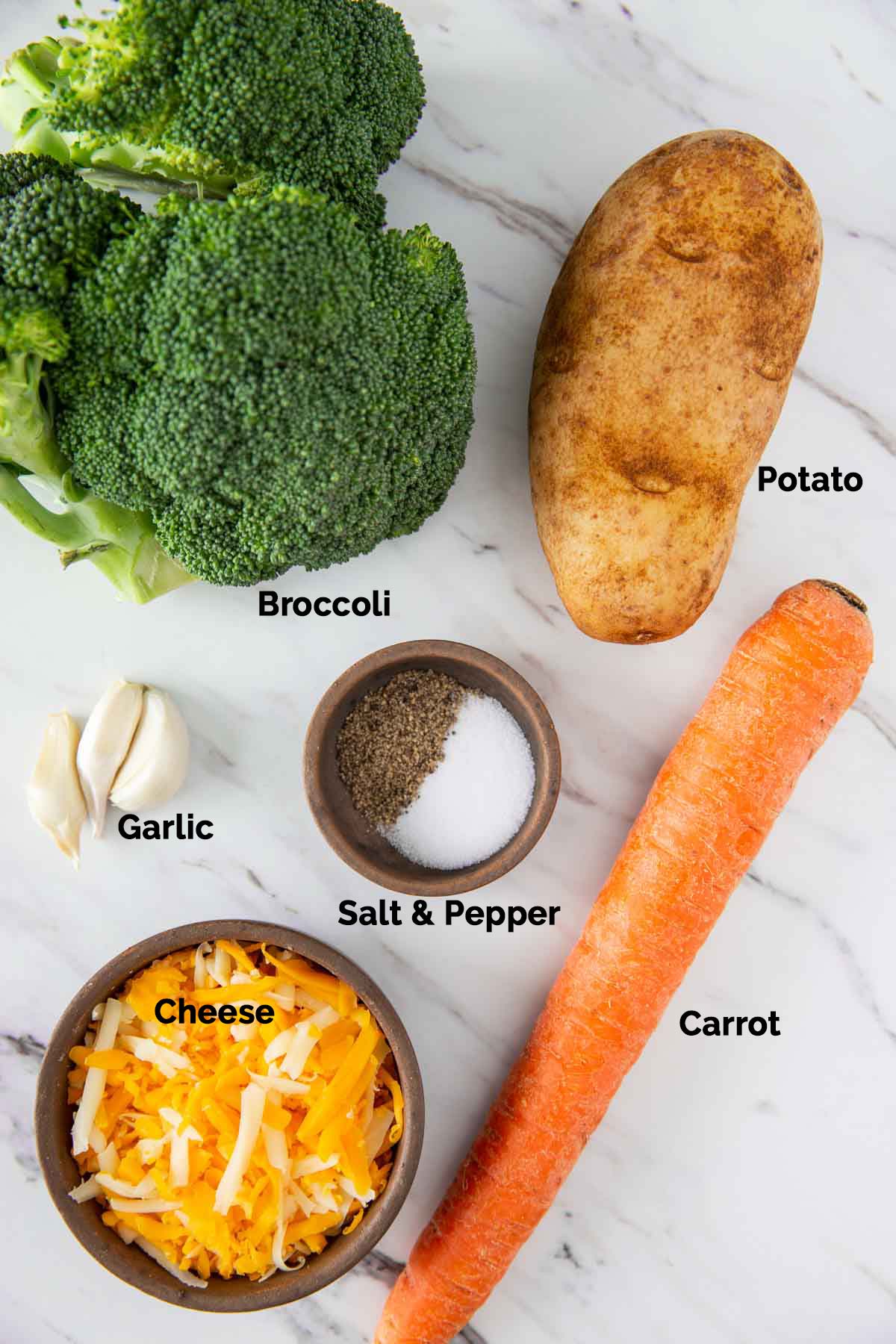 Fresh ingredients to prepare broccoli cheddar soup laid on a flat surface.