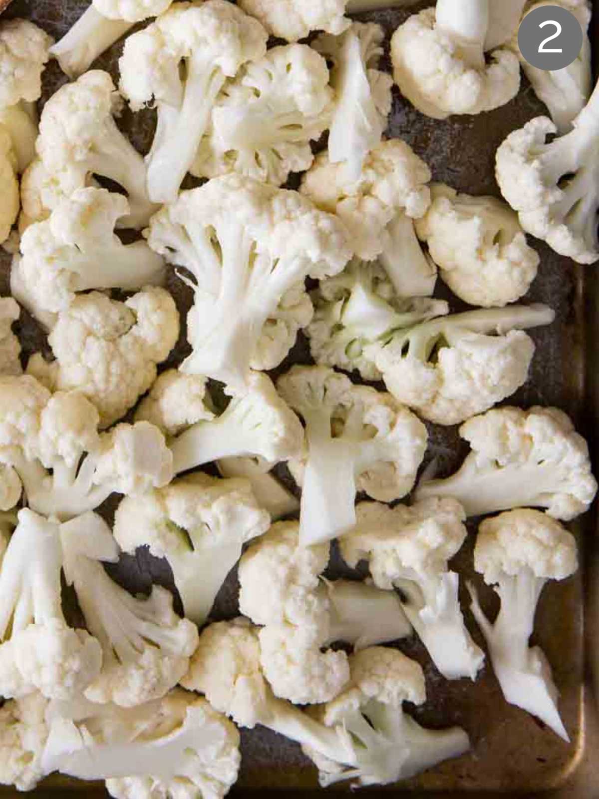 Cauliflower florets spread on a flat surface.