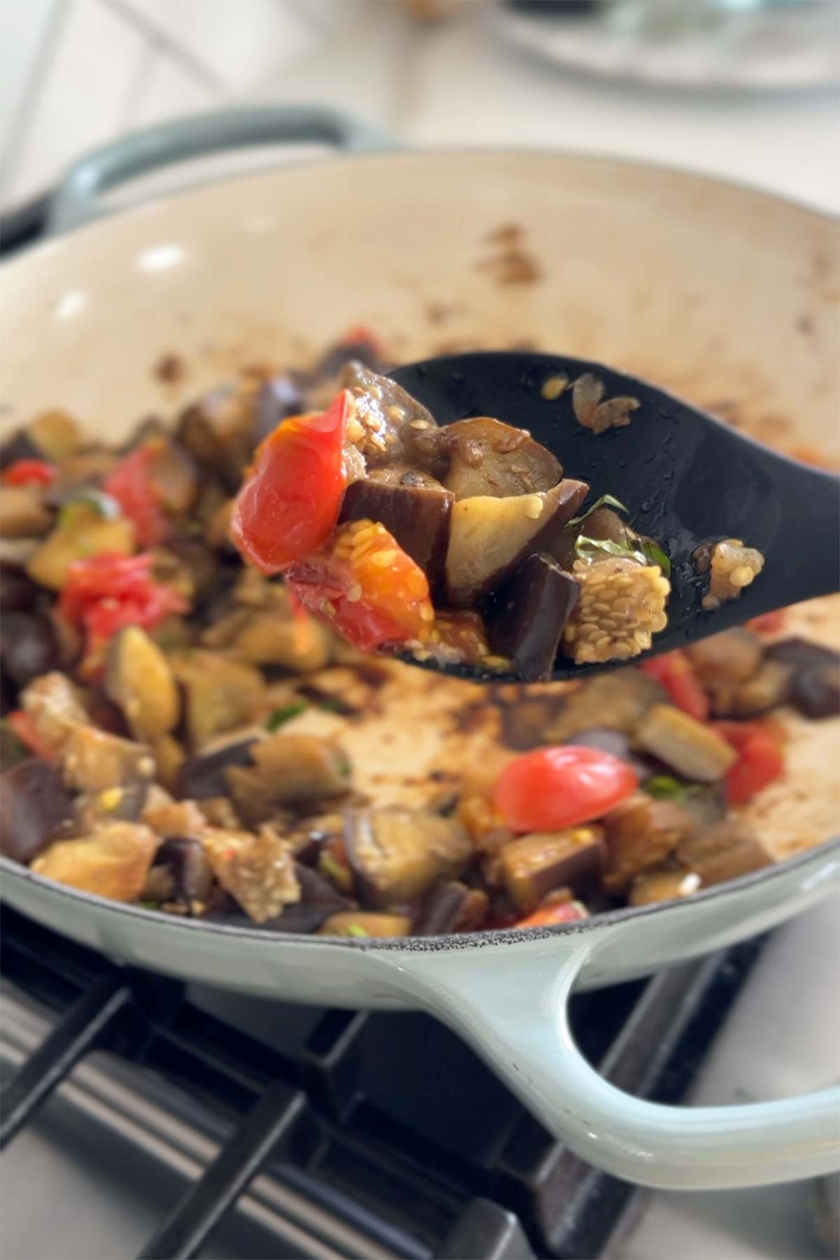Sauteed eggplant and tomatoes while serving.