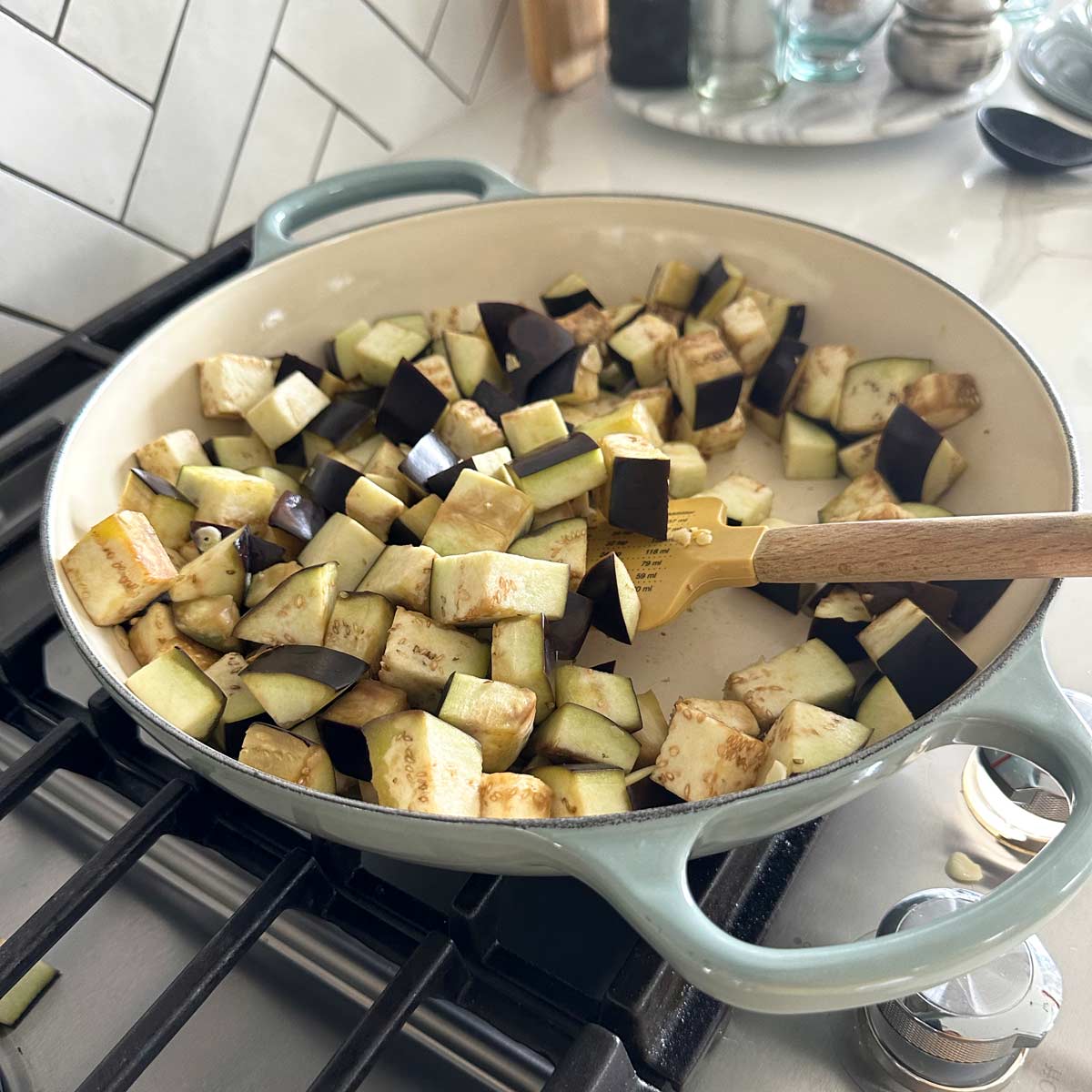 Sauteing eggplant with garlic in oil in a large skillet.