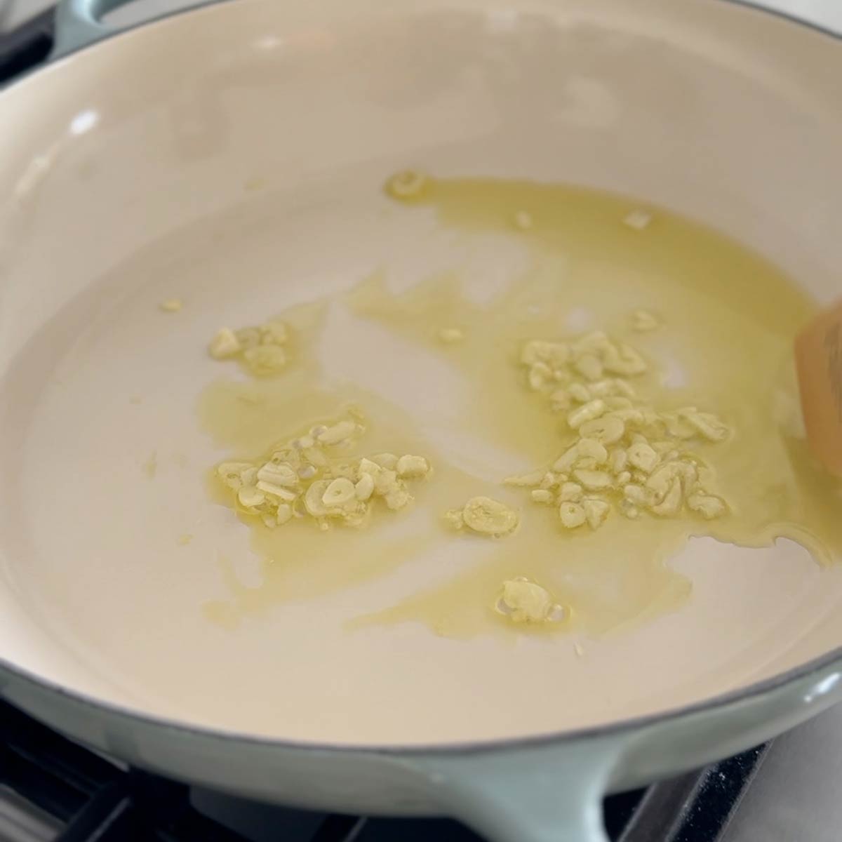 Sauteing garlic in oil in a large skillet.
