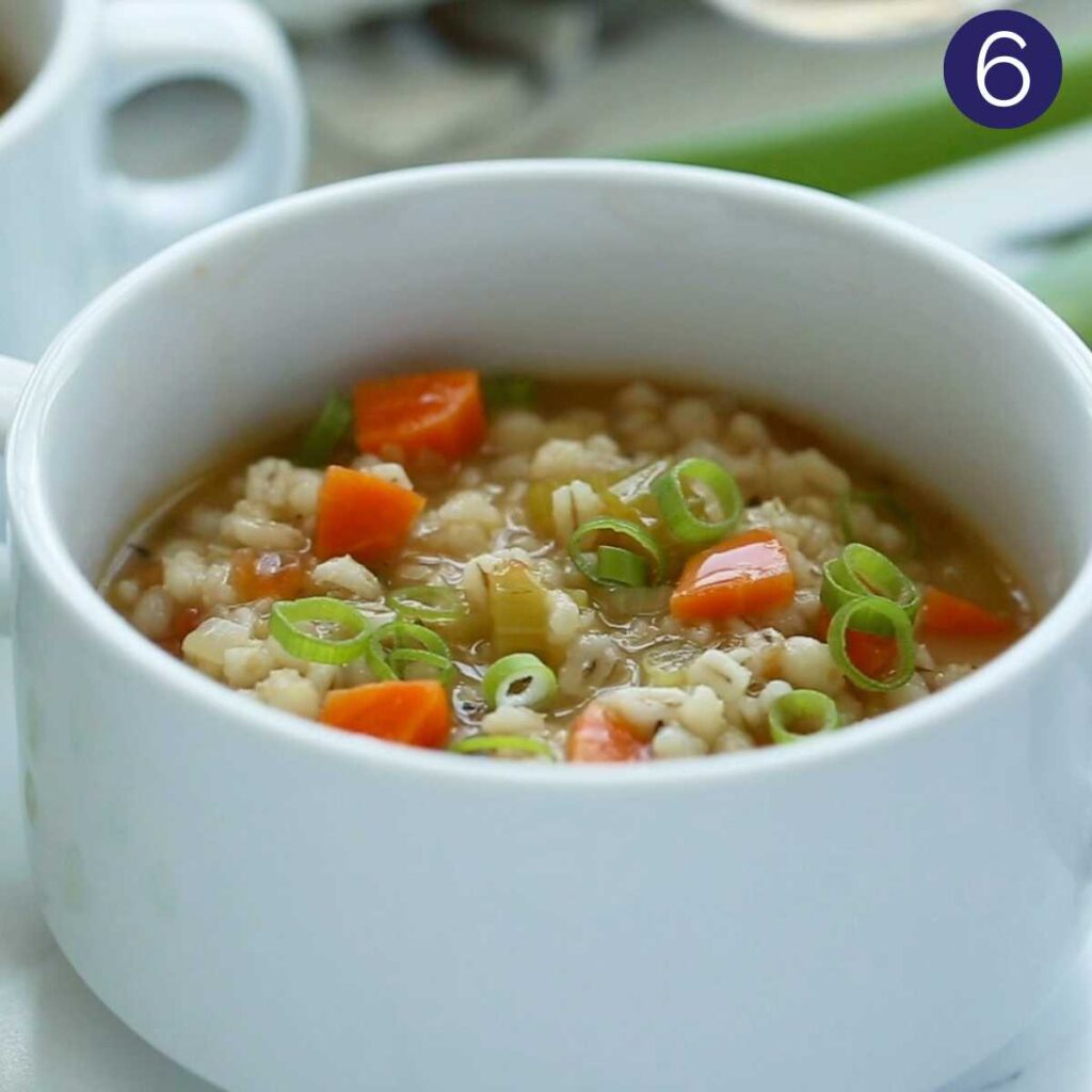Vegetable barley soup in a serving bowl.