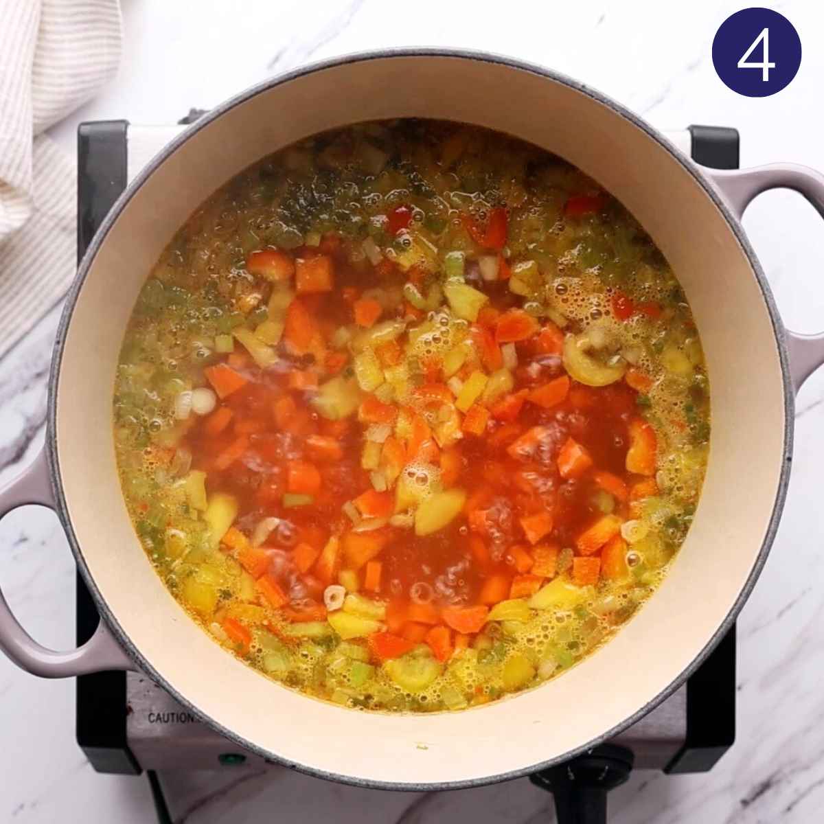 Cooking vegetables with broth in a cast iron pot.