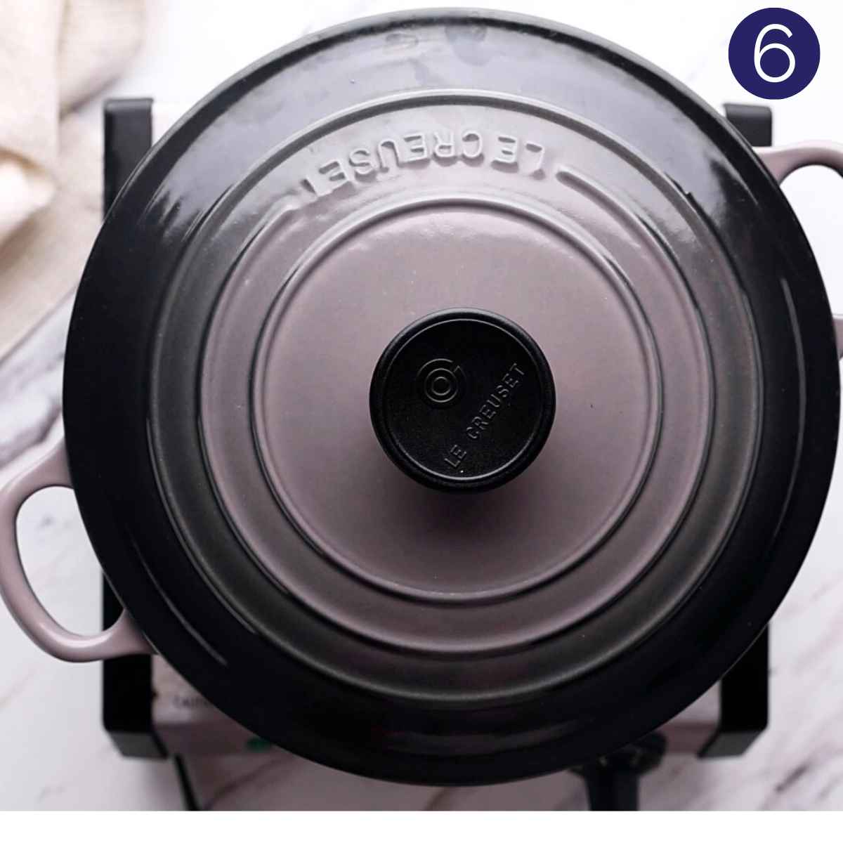 Cooking orzo soup in cast iron pan with lid on.