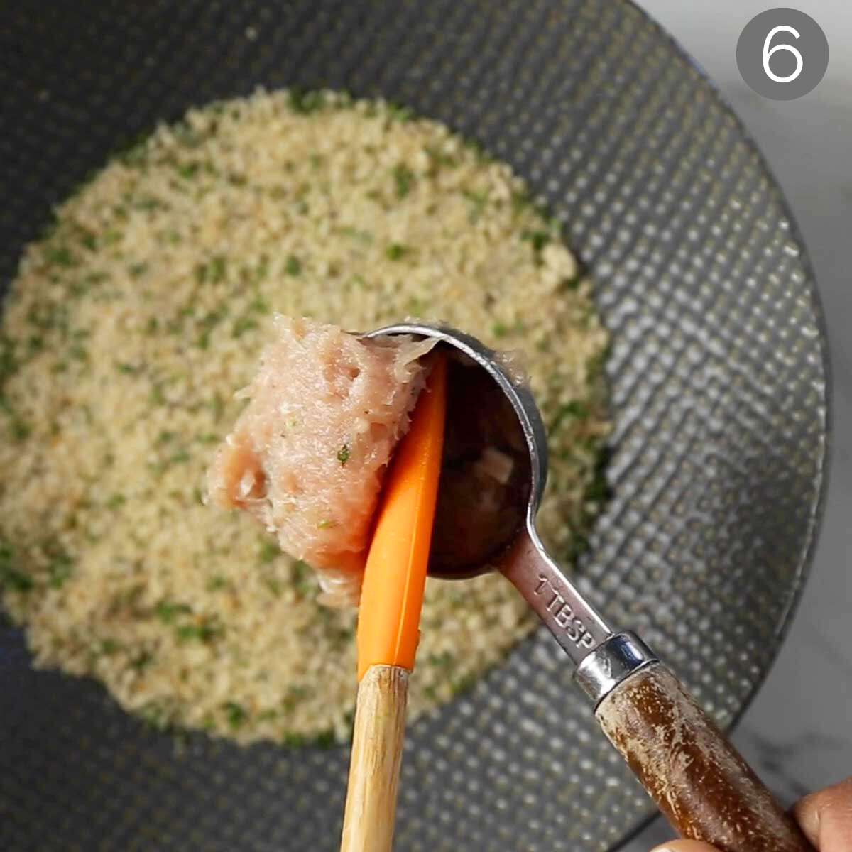 Making ground chicken with the help of a measuring spoon and small rubber spatula.