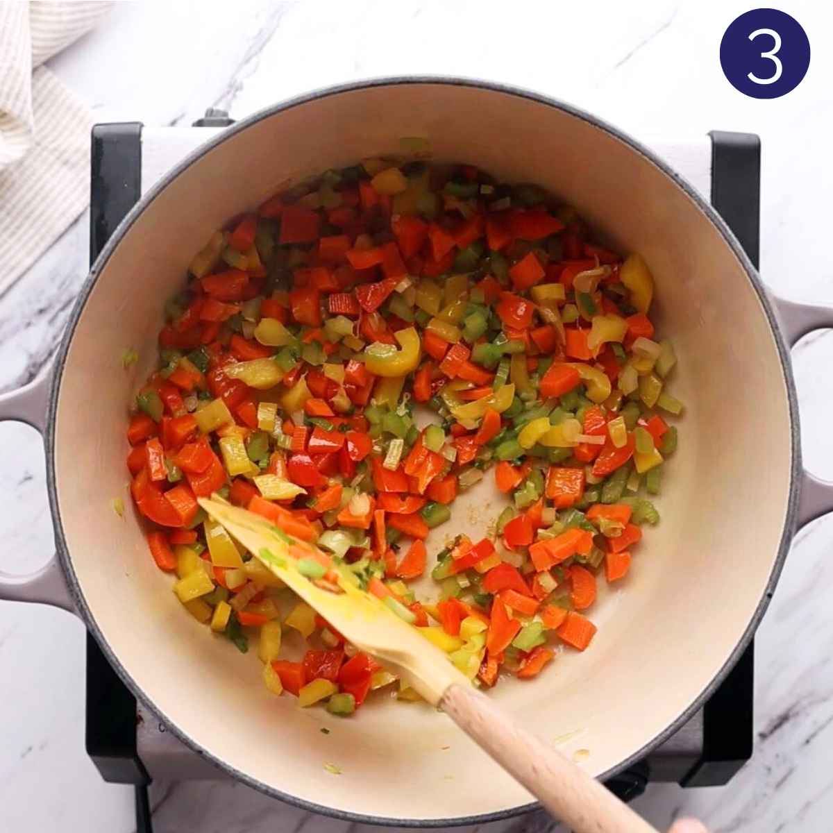 Sautéing vegetables in a cast iron pot.