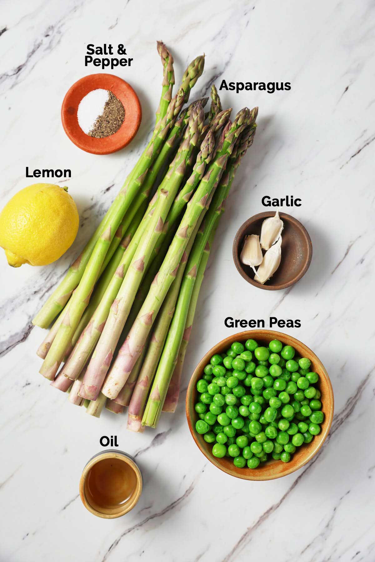 Ingredients for making sautéed asparagus and peas are placed on a flat surface.