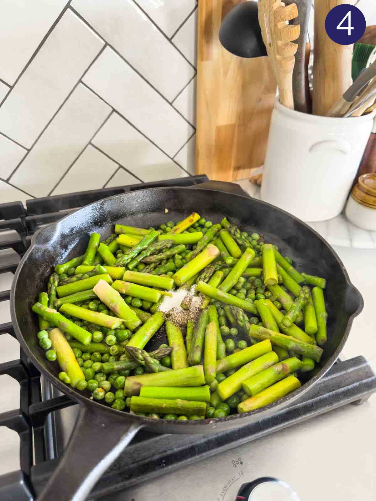 Seasoning roasted asparagus and green peas with salt and pepper. 