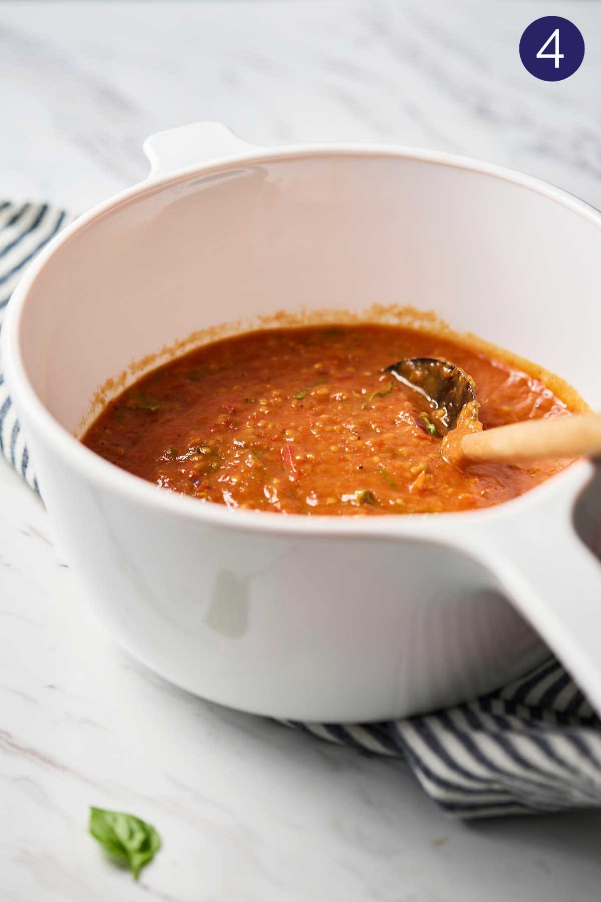 Cherry tomato sauce in a white ceramic saucepan after blending.