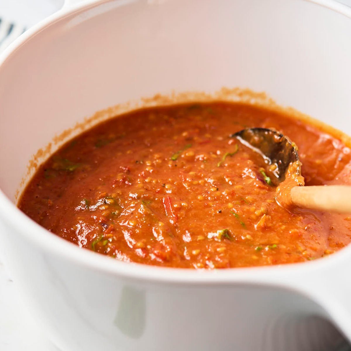 Cherry tomato sauce in a white ceramic saucepan after blending.