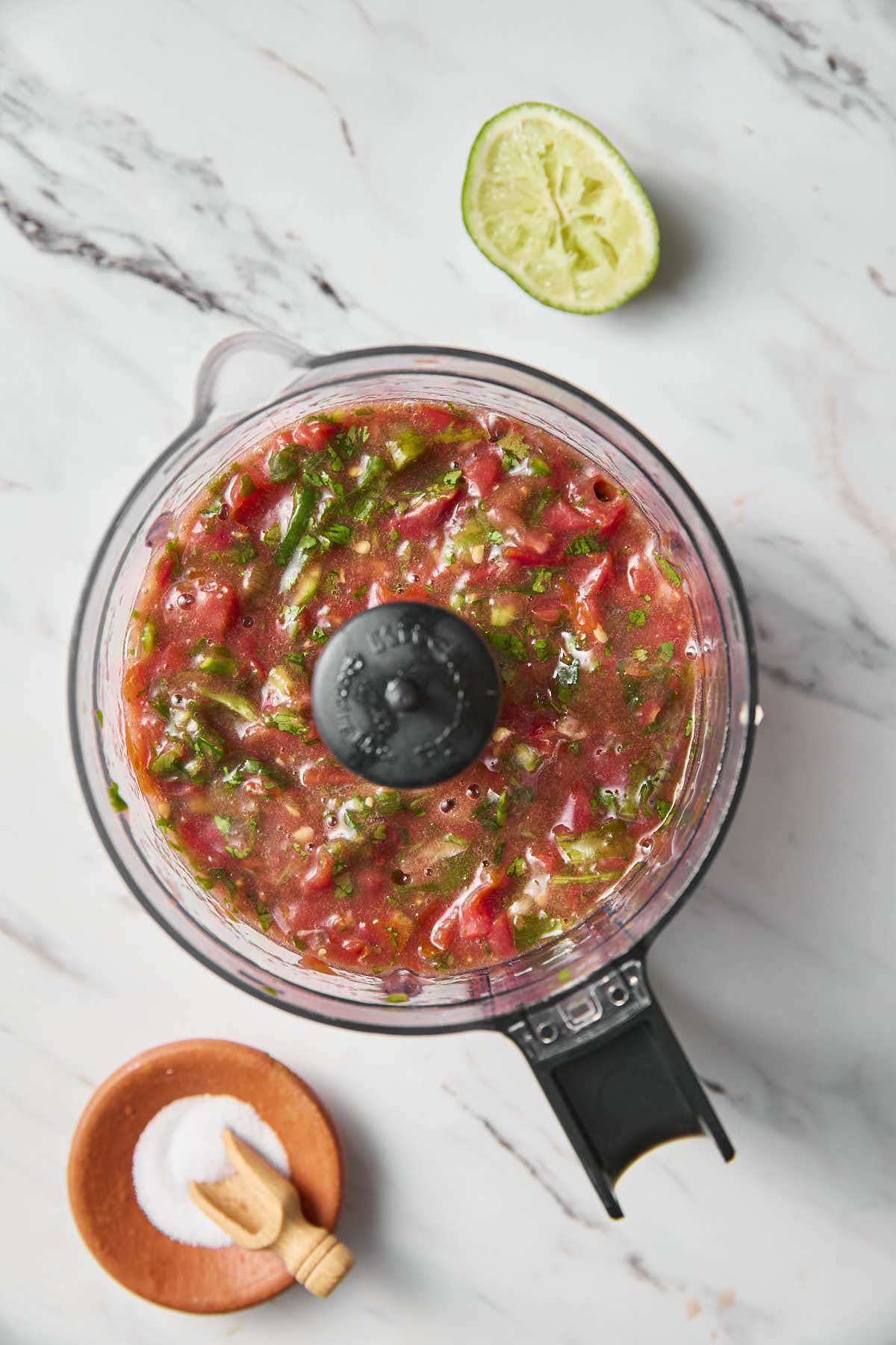 Garden-fresh salsa with cherry tomatoes after chopping in a blending jar.